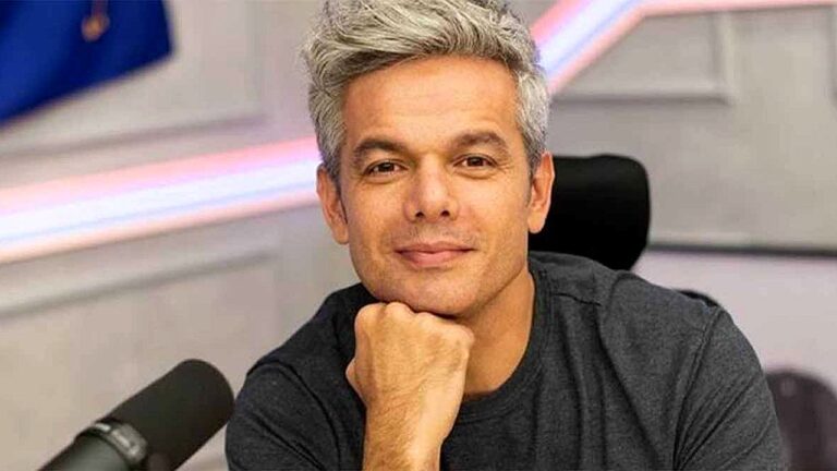 Otaviano Costa posa com o rosto apoiado na mão em estúdio de rádio durante participação em programa de entrevistas