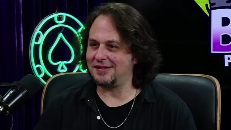 Rafael Blecher participa de podcast diante de microfone em estúdio com iluminação neon e cenário temático ao fundo