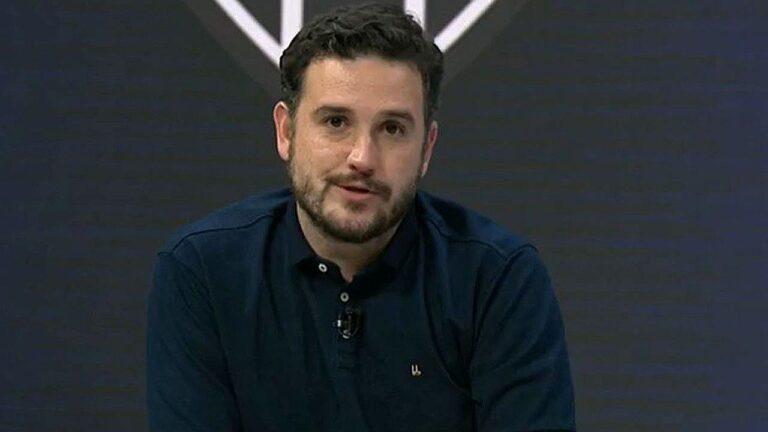Raphael Rezende durante apresentação em estúdio com camisa escura e expressão séria