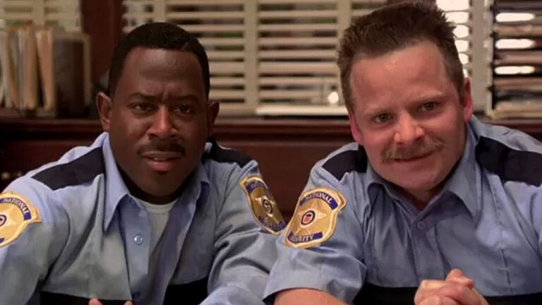 Martin Lawrence e Steve Zahn com uniformes de policiais observam algo com expressão surpresa em cena de comédia policial