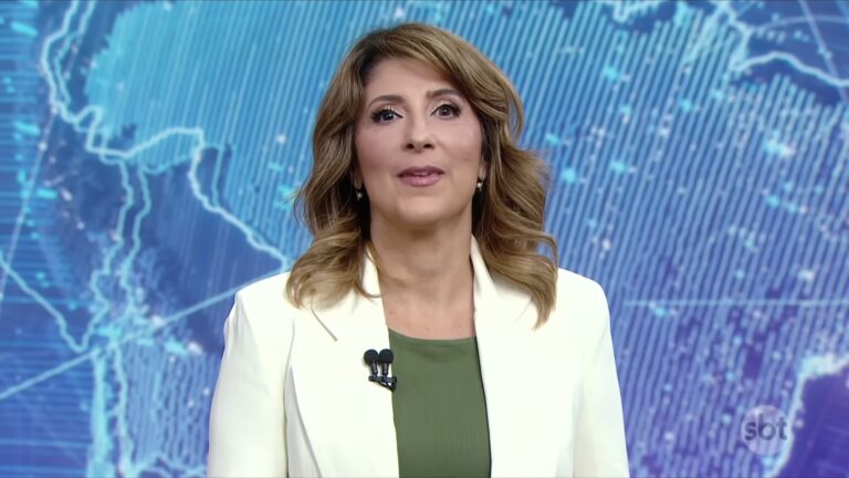 Simone Queiroz apresenta o SBT Brasil diante de painel com mapa digital no estúdio de telejornal da emissora