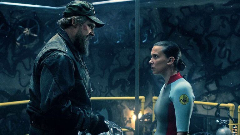 Homem de jaqueta e garota com uniforme encaram-se em laboratório subterrâneo em cena da série Stranger Things