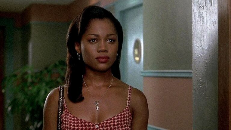 Theresa Randle com vestido estampado observa alguém à porta em cena do filme Bad Boys 2