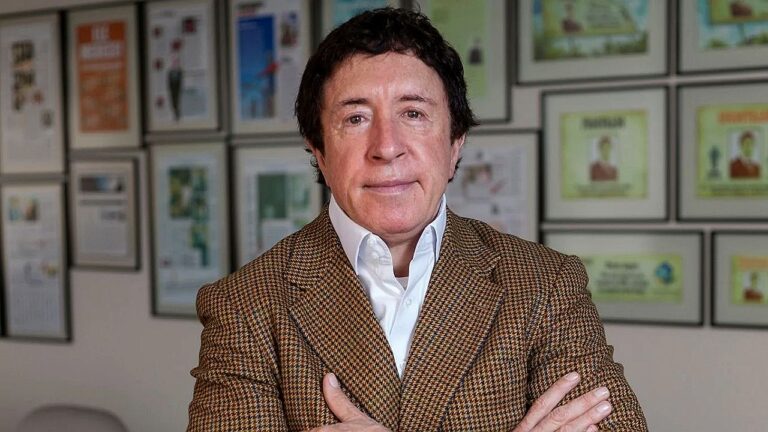 Walter Zagari de braços cruzados em escritório com quadros emoldurados ao fundo durante entrevista institucional