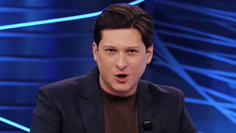 Willian Kury fala durante estreia do RedeTV! Notícias em estúdio com iluminação azul ao fundo