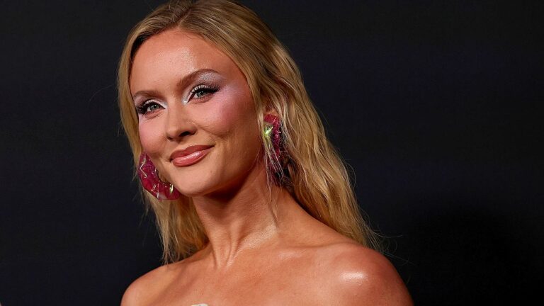 Zara Larsson posa com vestido tomara que caia e brincos rosa durante evento de divulgação musical