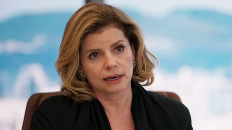 Débora Bloch com expressão séria durante reunião em cena da novela Vale Tudo