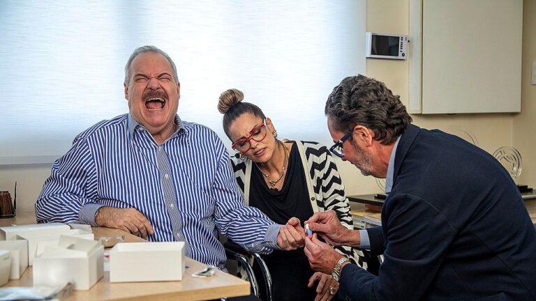 Gilberto Barros faz exame de glicemia com ajuda de médico enquanto Suzy Rêgo acompanha a consulta no Domingo Espetacular