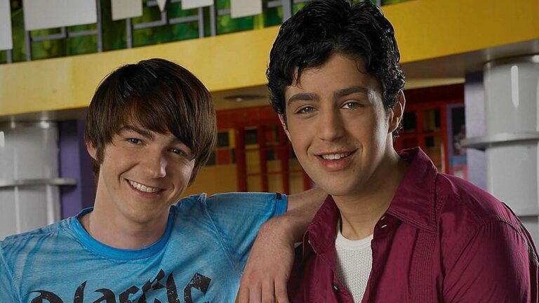 Drake Bell e Josh Peck sorriem lado a lado em cena da série Drake & Josh no corredor da escola