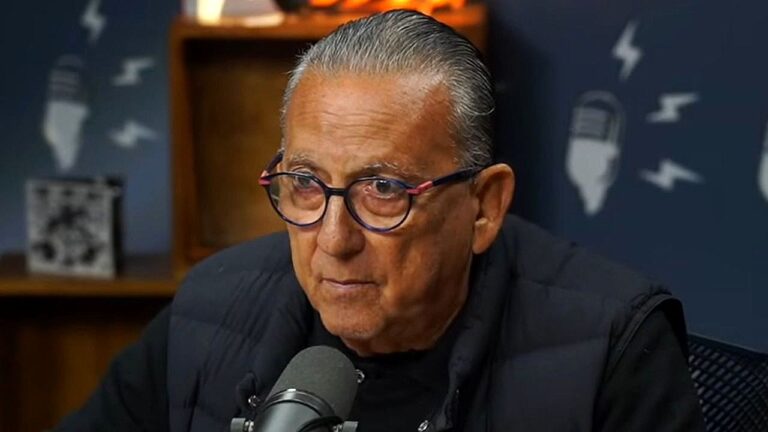 Galvão Bueno fala ao microfone durante participação em podcast com estúdio e bancada ao fundo