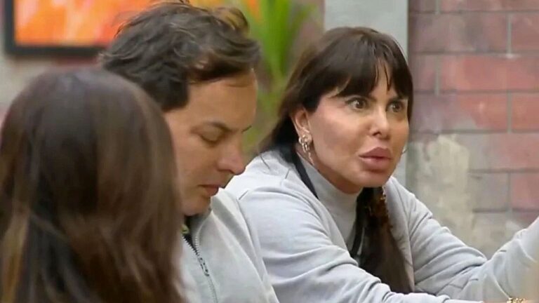 Gretchen conversa à mesa com outros participantes em cena de reality show ao lado do marido Esdras de Souza