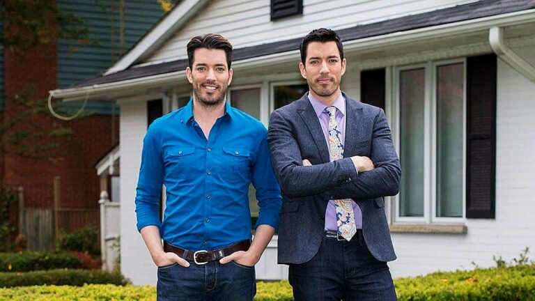 Jonathan e Drew Scott posam em frente a uma casa em foto promocional do programa Irmãos à Obra