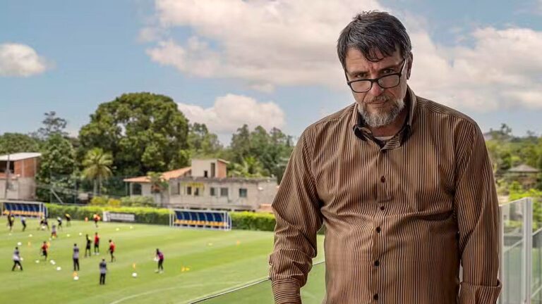 Rodrigo Lombardi observa campo de futebol em cena da série Jogada de Risco