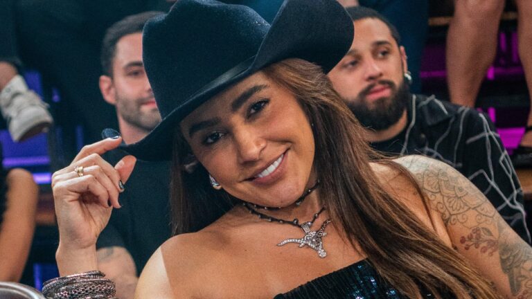 Lauana Prado de chapéu preto sorri para a câmera com plateia do Altas Horas ao fundo