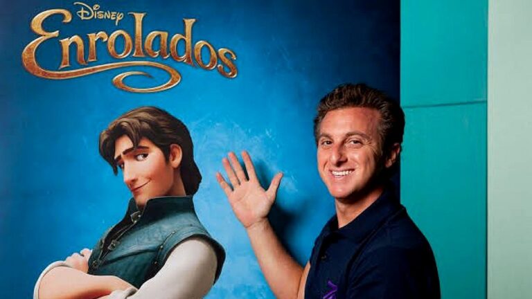 Luciano Huck posa ao lado de pôster do filme Enrolados durante evento de divulgação da Disney
