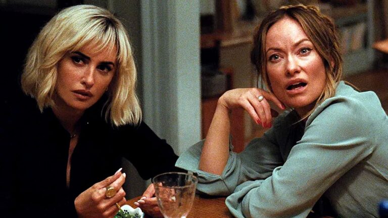 Olivia Wilde e personagem de Penélope Cruz observam alguém com expressão de surpresa em cena de um filme