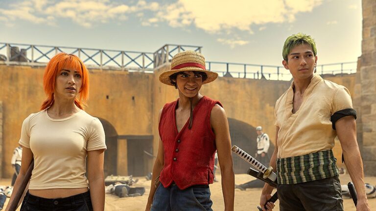 Nami, Luffy e Zoro em cena da série One Piece durante confronto em pátio cercado por soldados