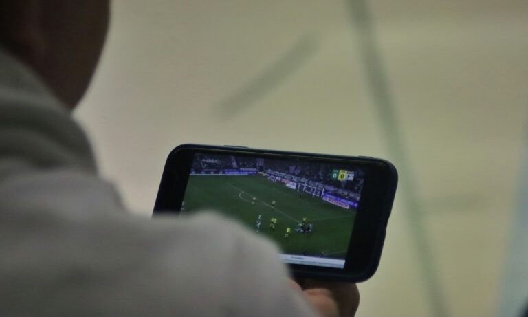 Foto de pessoa assistindo a um jogo da Copa do Mundo em seu celular