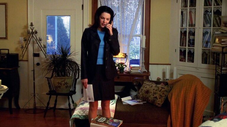 Lorelai Gilmore fala ao telefone na sala de casa em cena da primeira temporada de Gilmore Girls