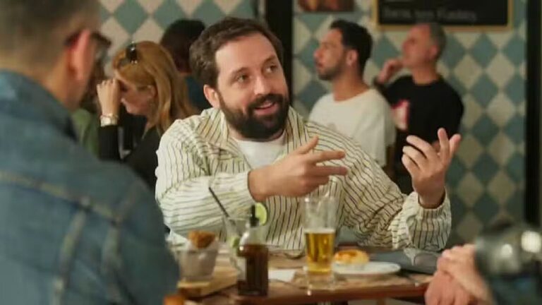 Homem gesticula enquanto conversa com amigos em mesa de bar em cena de esquete do Porta dos Fundos