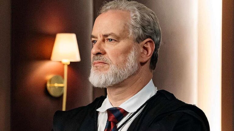 Ademir encara o tribunal com expressão séria em cena da novela Quem Ama Cuida