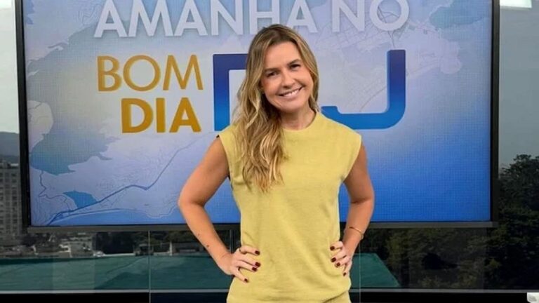 Silvana Ramiro sorri no estúdio do Bom Dia RJ diante do telão com a identidade visual do telejornal
