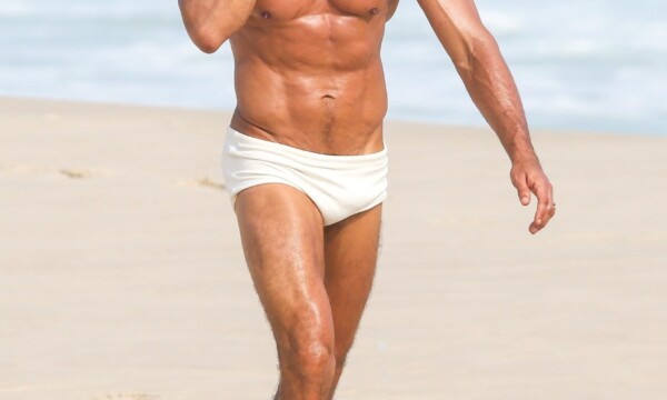 Cauã Reymond (foto: Dilson Silva/AgNews) Cauã Reymond durante gravações do remake de Vale Tudo na praia da Barra da Tijuca, no Rio de Janeiro, usando sunga branca e falando ao celular enquanto caminha na areia