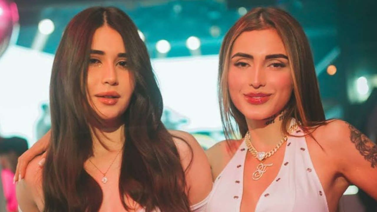 Sabrina Pimenta com cabelo escuro e Fernanda Campos com cabelo loiro e colar dourado em ambiente de festa noturna