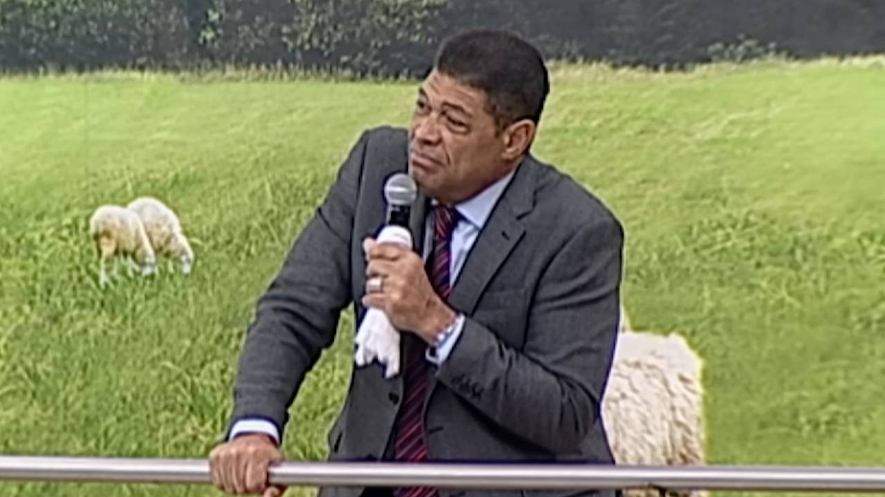 Valdemiro Santiago segura microfone durante pregação em cenário com imagem de ovelhas no campo