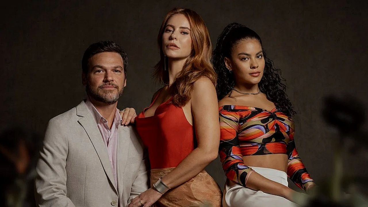 Trio de personagens posa junto em ensaio promocional com figurinos elegantes em destaque para novela brasileira