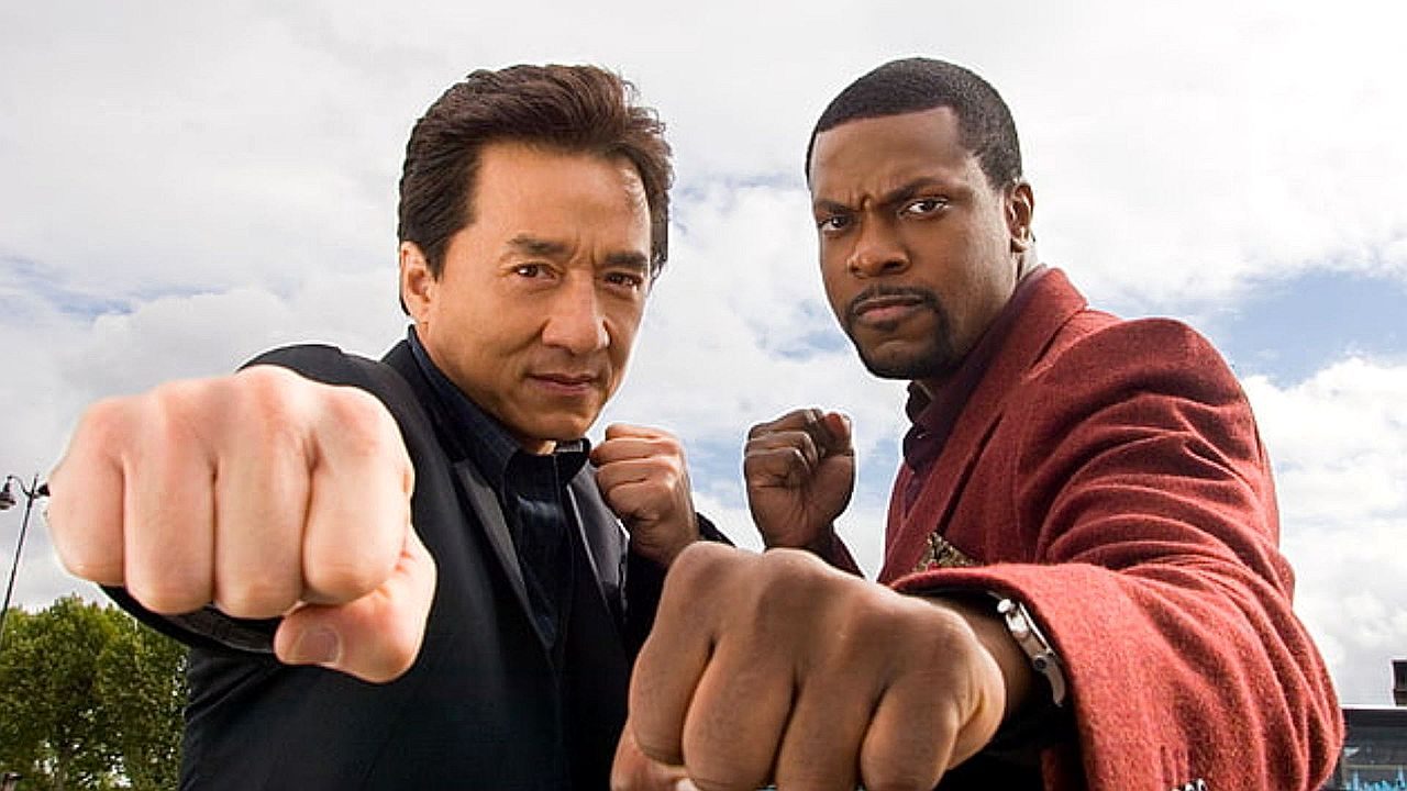 Jackie Chan e Chris Tucker com punhos cerrados em pose de luta em cena da franquia A Hora do Rush