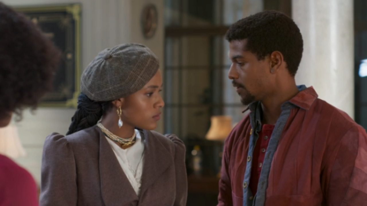 Casal discute frente a frente em cena de novela dentro de casa com decoração ao fundo