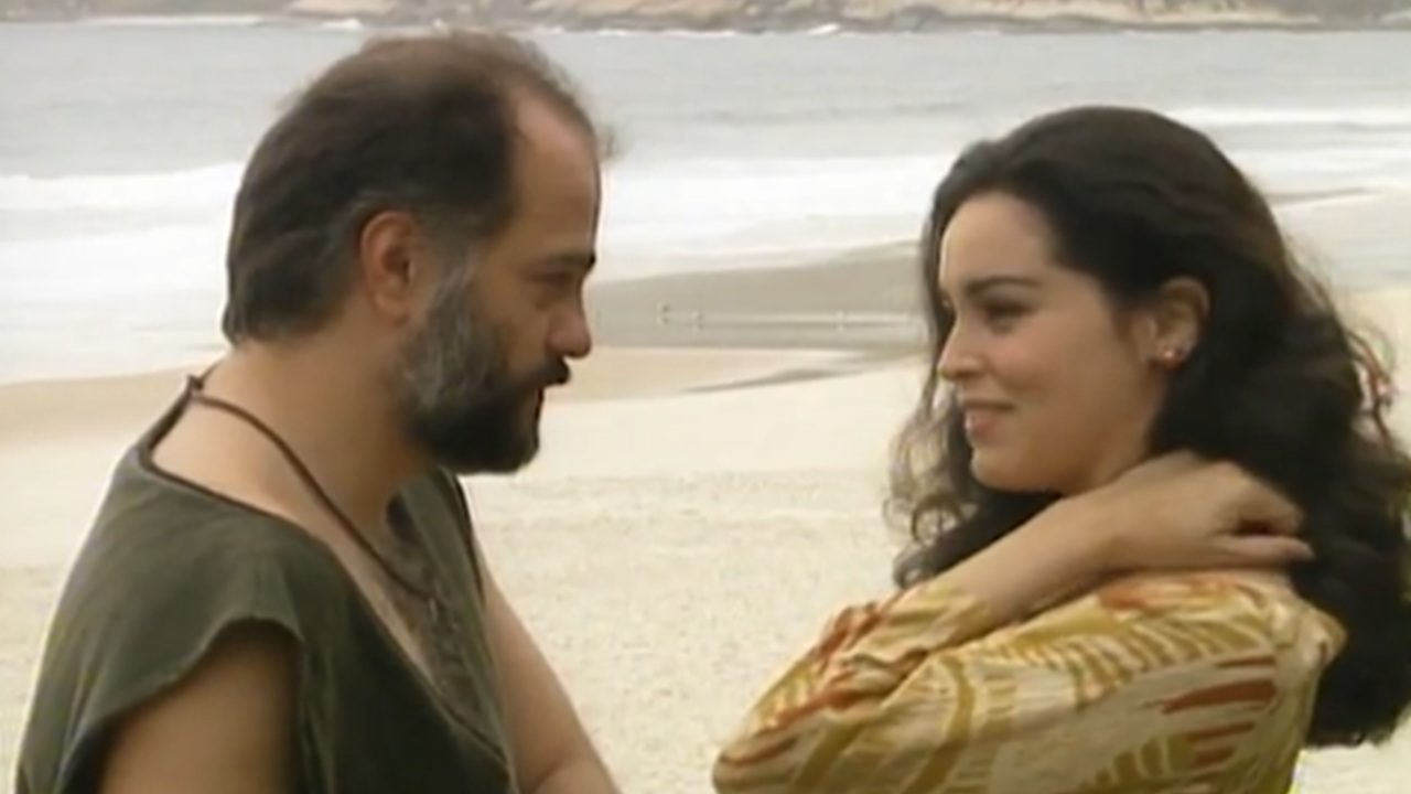 Carmem conversa com Igor na praia em cena de A Viagem após decidir se afastar do Mascarado