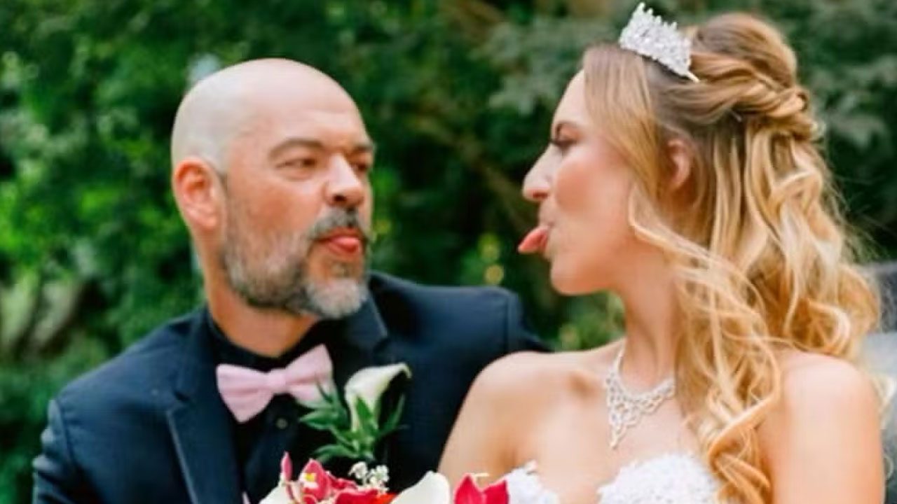Aaron Goodwin e Victoria Goodwin trocando caretas divertidas durante cerimônia de casamento ao ar livre em 2022