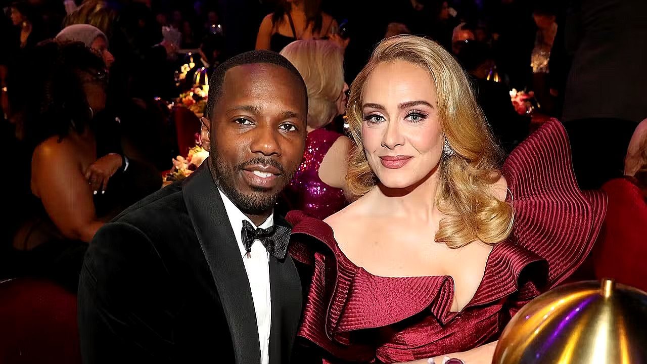 Adele posa ao lado de Rich Paul durante evento de gala com trajes formais e mesas ao fundo