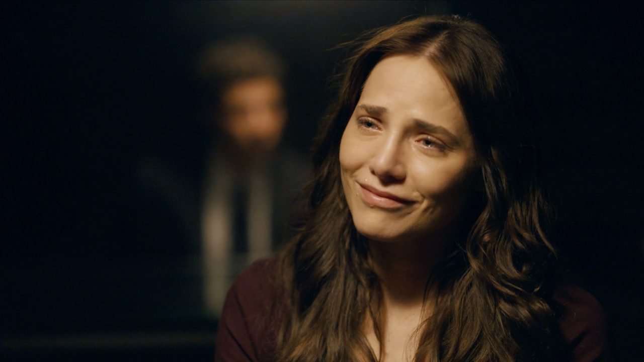 Adriana (Letícia Colin) com lágrimas nos olhos e leve sorriso em cena da novela Quem Ama Cuida