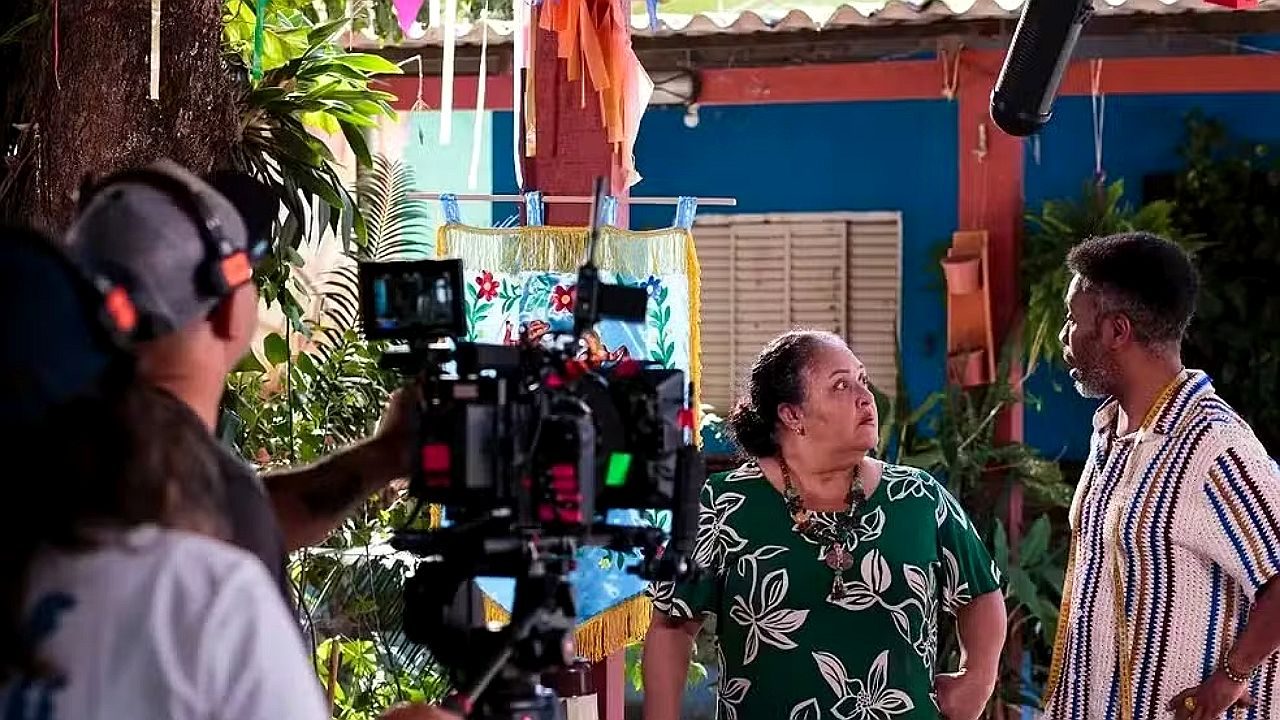 Equipe de filmagem grava cena com dois personagens em área externa no filme Amor em Movimento