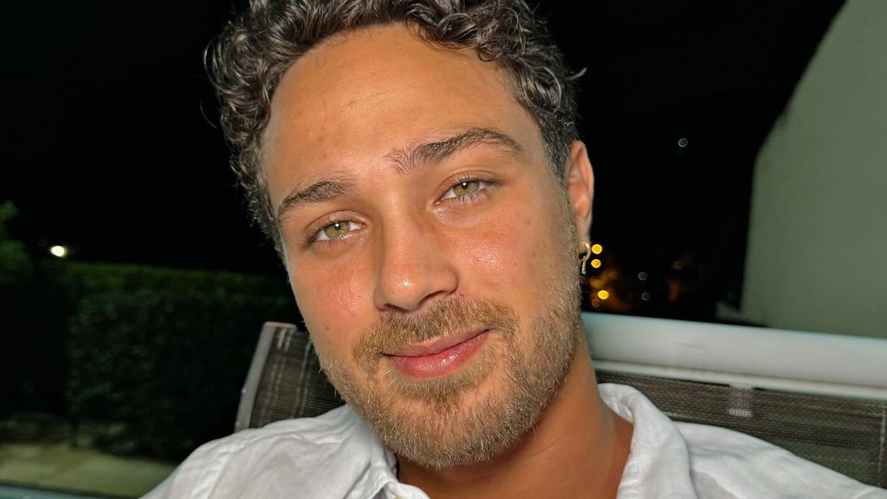 André Luiz Frambach com camisa branca sorrindo em ambiente externo à noite