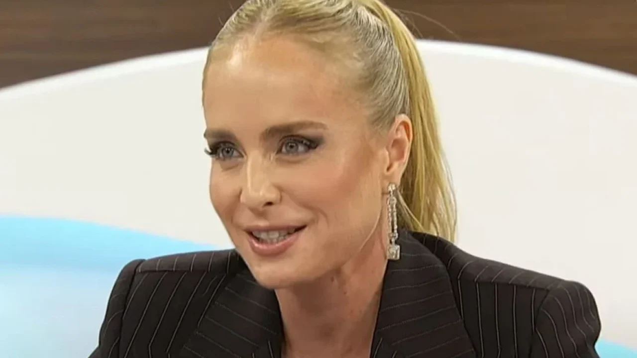 Angélica com uma roupa preta no estúdio de um programa de TV