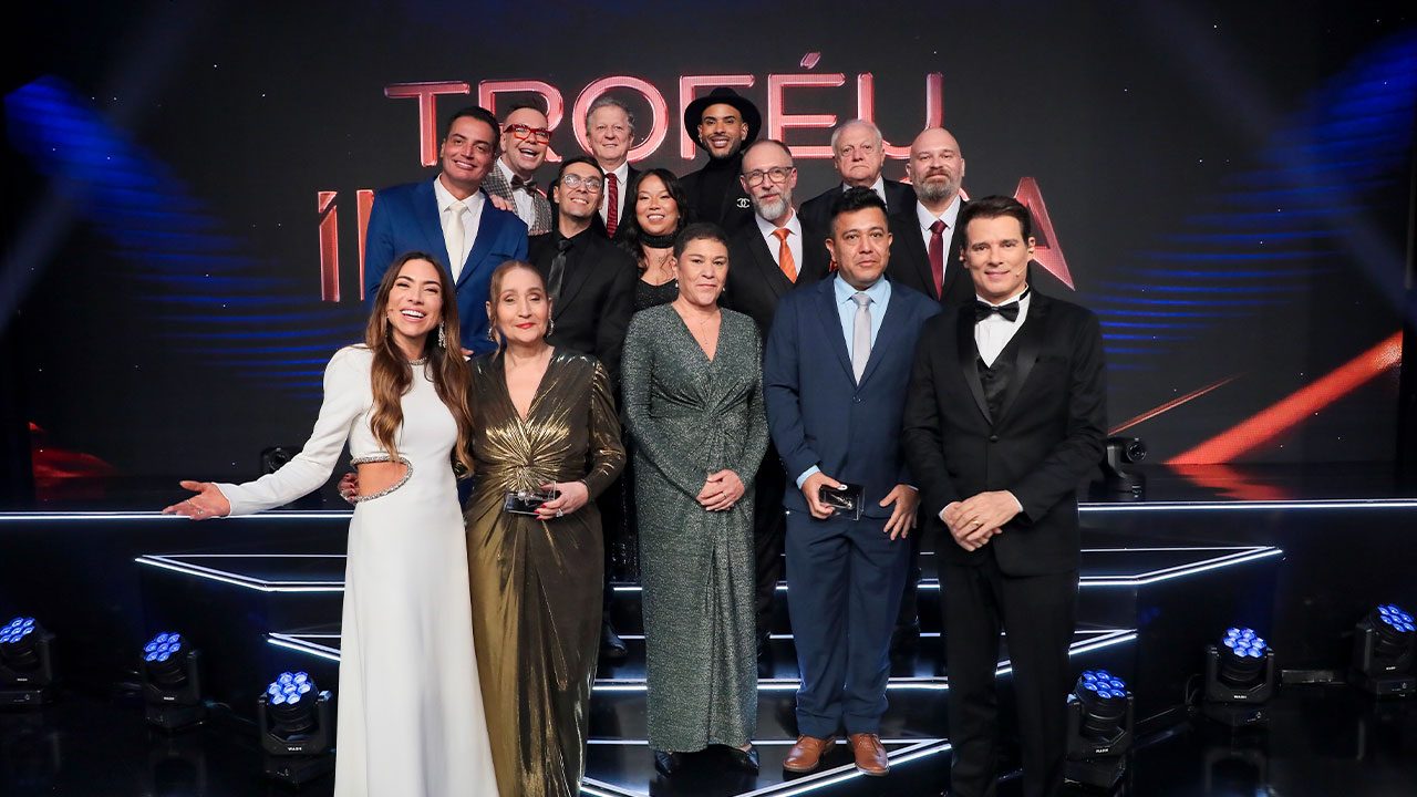 Apresentadores e jurados posam no palco iluminado durante cerimônia do Troféu Imprensa no SBT