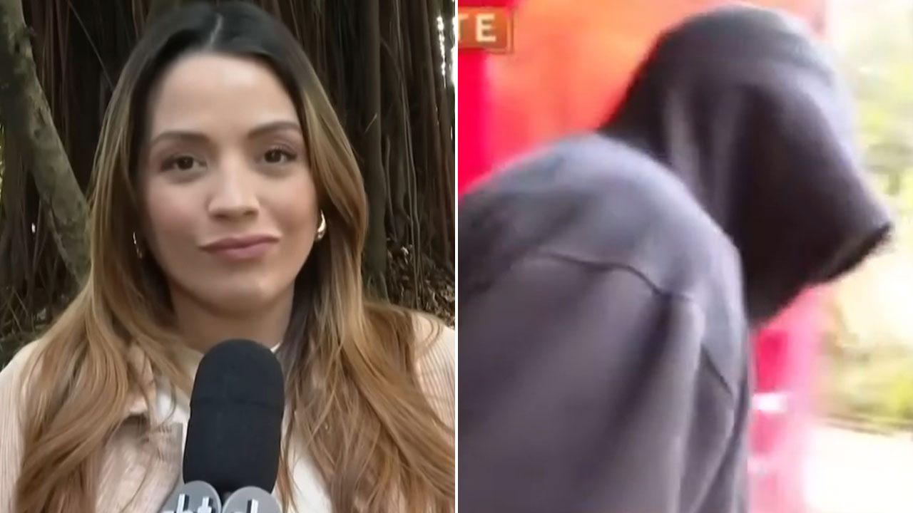 Ariany Rollim com microfone do SBT durante reportagem na rua ao lado de suspeito encapuzado escoltado