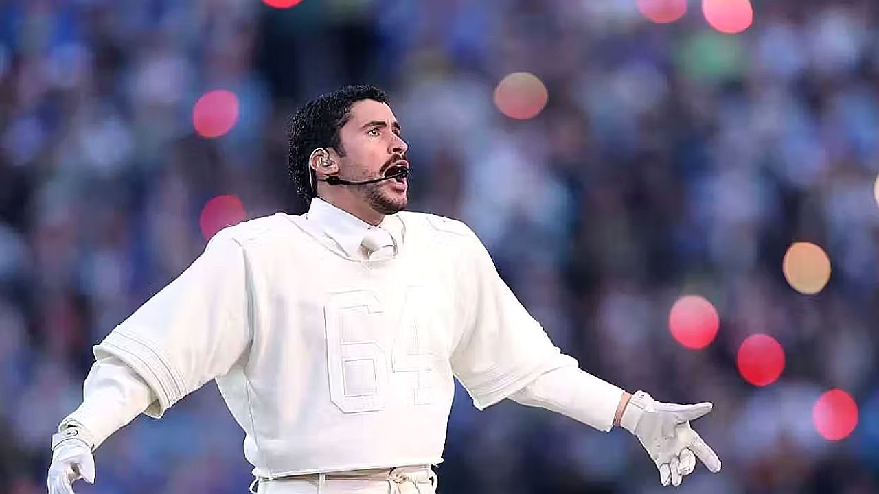 Bad Bunny canta com figurino branco e microfone de cabeça durante apresentação em estádio lotado