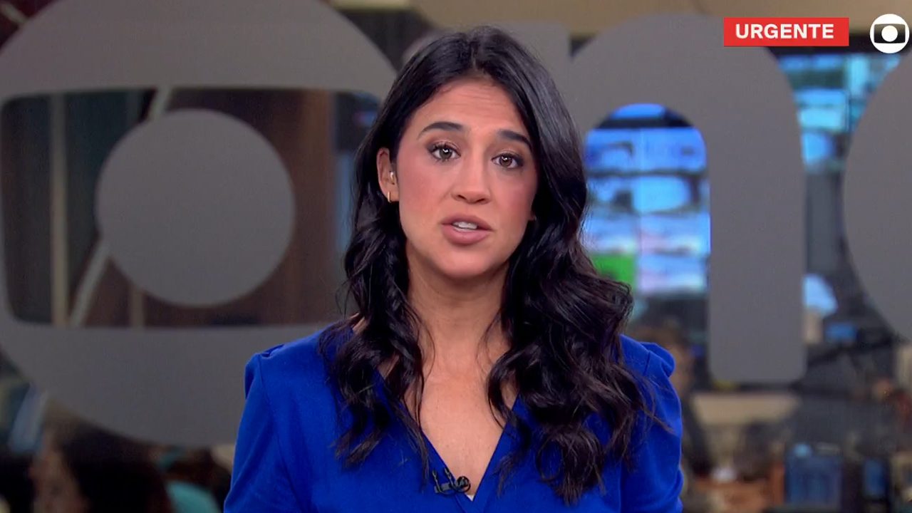 Bárbara Carvalho com expressão séria durante plantão de notícia urgente na GloboNews