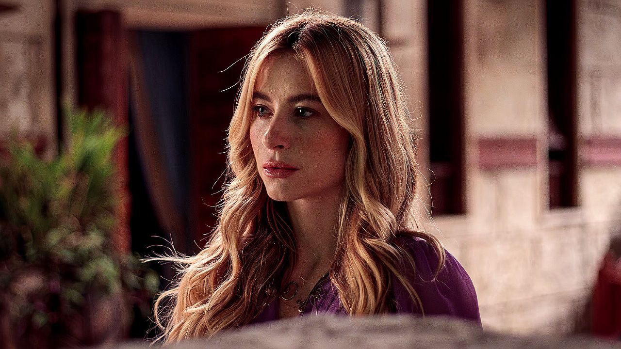 Atriz loira com expressão séria em cena de novela ambientada em casarão histórico