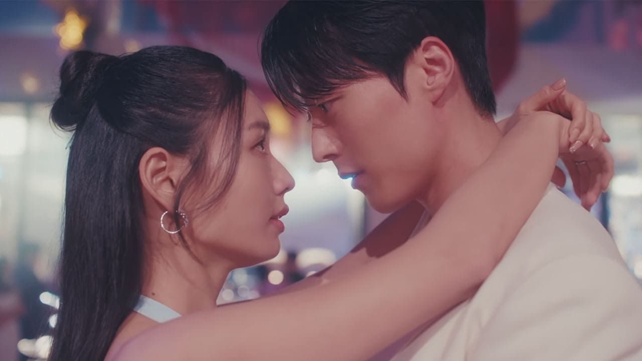 Homem e mulher se encaram de perto com braços entrelaçados dançando sob luz suave em ambiente festivo