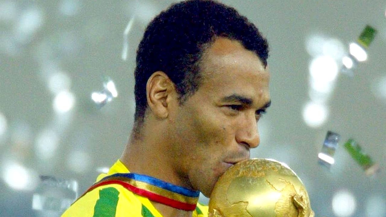 Atleta beijando uma taça com a camisa da seleção brasileira
