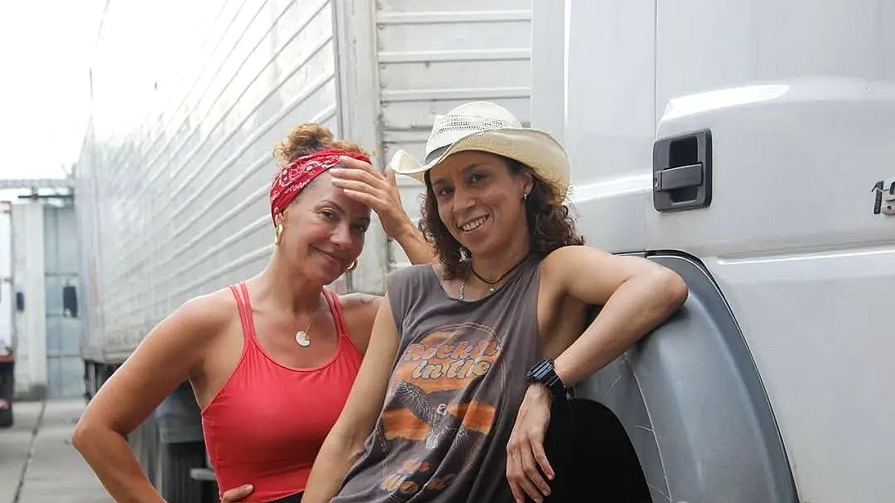 Personagens de Carga Pesada posam ao lado de caminhão em cena da série sobre a vida nas estradas brasileiras