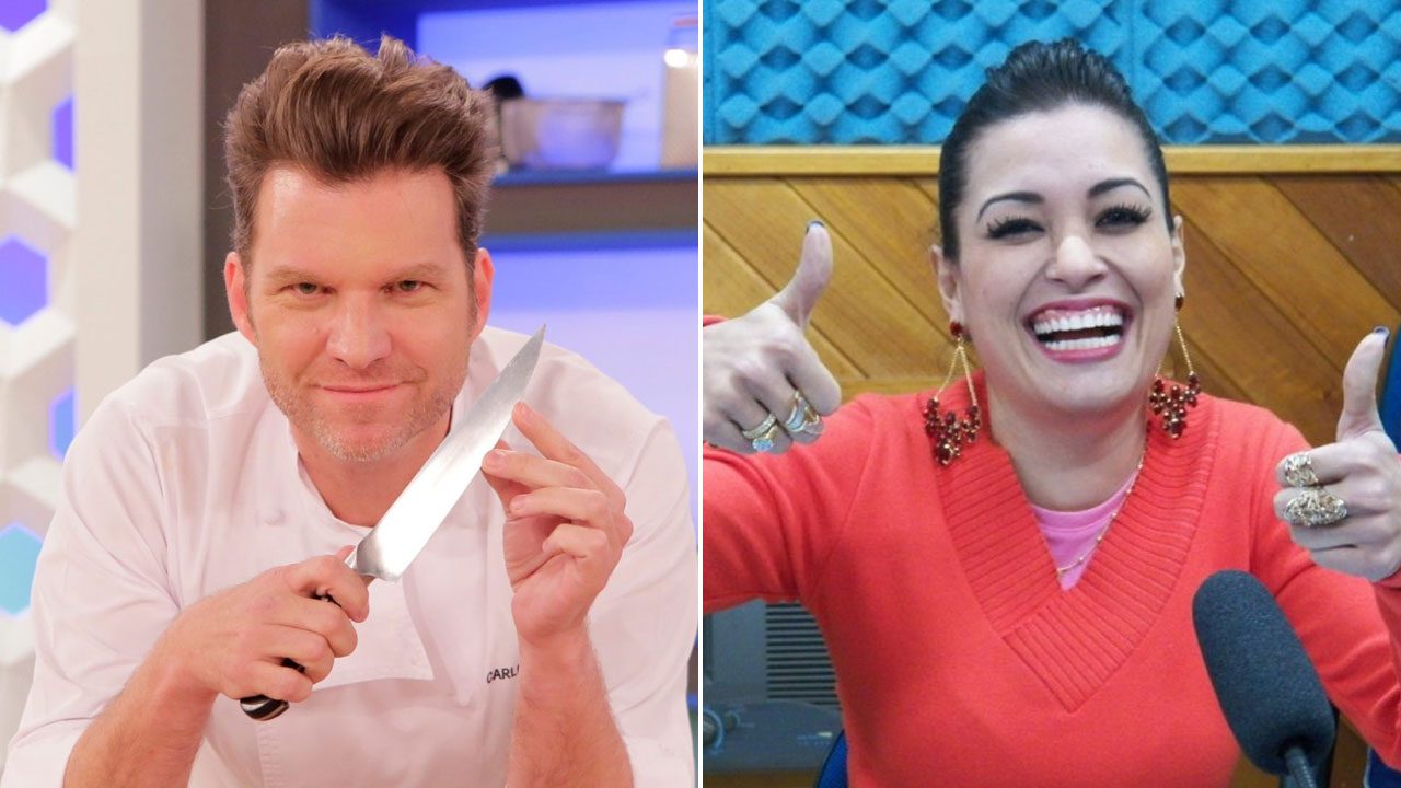 Carlos Bertolazzi segura uma faca de chef e sorri ao lado de Milene Pavorô sorrindo e fazendo joinha com as mãos