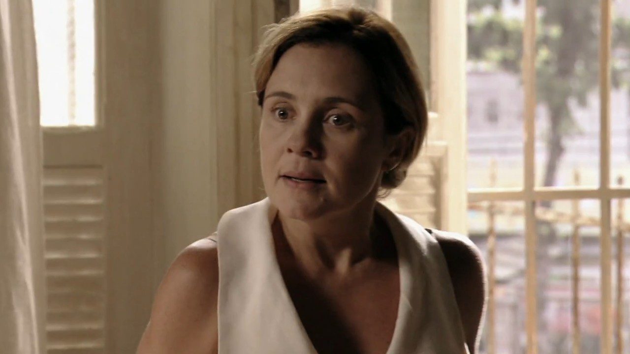 Carminha (Adriana Esteves) com expressão tensa em cena da novela Avenida Brasil dentro de casa iluminada