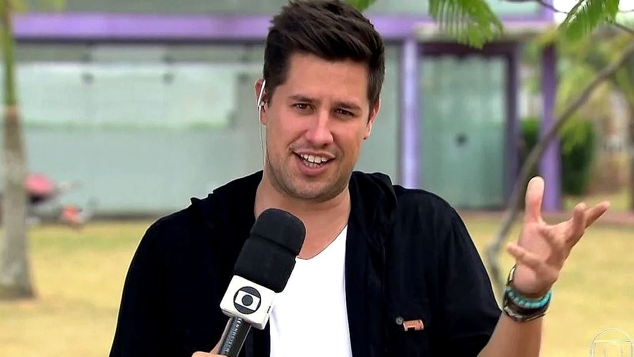 Cassio Barco concede entrevista à TV Globo durante cobertura de evento ao ar livre com microfone da emissora